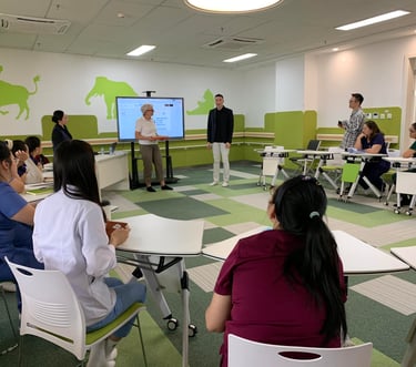 A modern healthcare training room where staff attend a digital presentation on a smart screen.