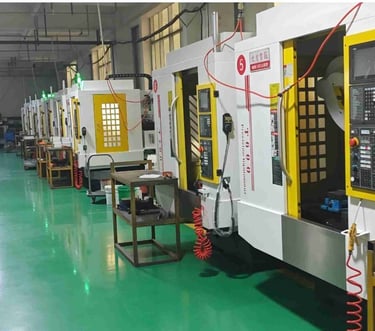 Industrial factory floor with a row of high-precision CNC milling machines for metal parts manufacturing.