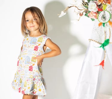 a little girl standing in front of a teepee
