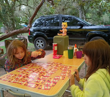 Crianças jogando cartas no acampamento