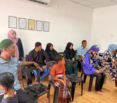 A group of people sitting in a clinic waiting room for medical appointments.