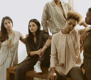 Diverse group of women posing together in neutral fashion.