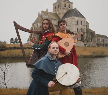 3 musiciens médiévaux devant une abbaye et un lac