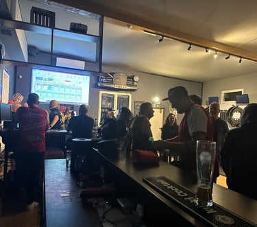 a man is standing in a bar with a glass of beer