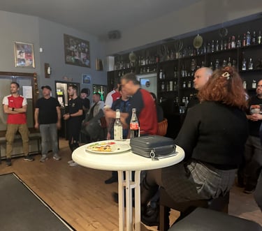 a group of people standing around a table with pizza