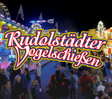 Das Logo des Rudolstädter Vogelschießens vor dem Hintergrund eines belebten nächtlichen Jahrmarkts