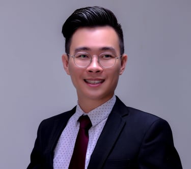 a man in a suit and tie standing in front of a white wall