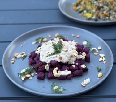 a plate of beetroot gnocchi on a table with a plate of food