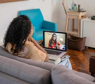 a woman sitting on a couch with a laptop computer