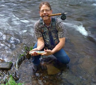 Photo of Robert E. Saunders with flyrod and trout