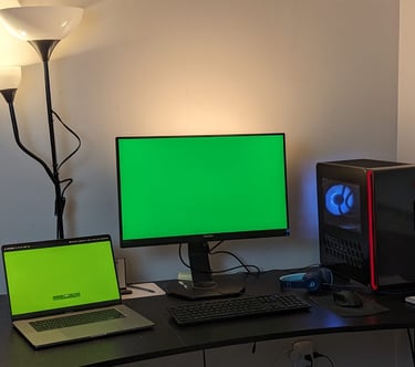 a desk with a laptop and a computer monitor