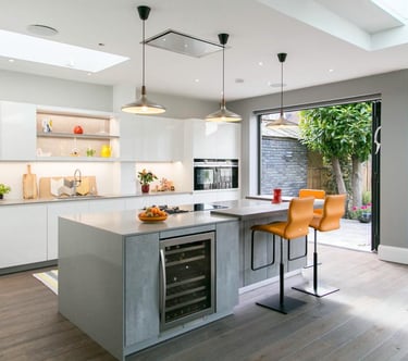 an open plan modern kitchen with orange bar stools, grey concrete  island cabinets, dark wood floor