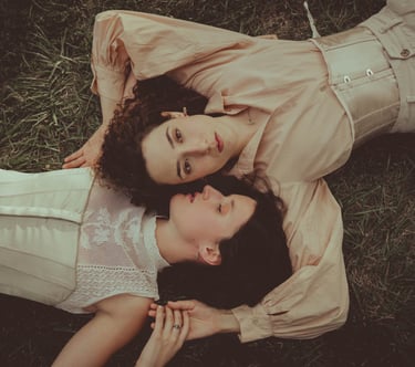 "Pareja lesbiana vista desde arriba, abrazándose en el suelo, celebrando el amor en una boda gay."