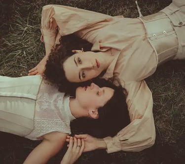 "Pareja lesbiana vista desde arriba, abrazándose en el suelo, celebrando el amor en una boda gay."