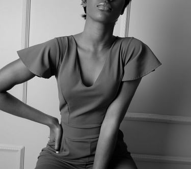 Photo mode femme noire au visage cachée assise sur un tabouret place sa main droite sur sa taille