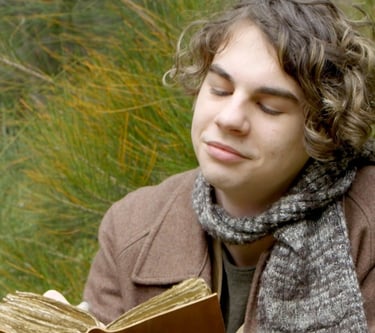 a man in a brown jacket is holding a book