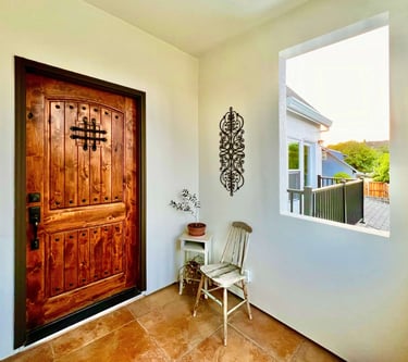Welcoming entryway with a warm stained wood door and seating area.