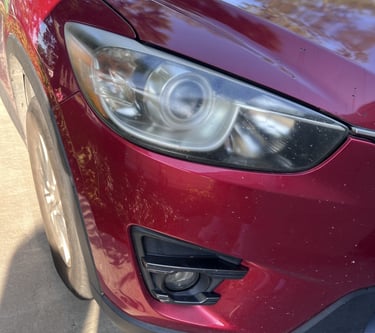 before image of shiny red car's headlight