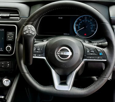 A Nissan steering wheel with a mounted steering ball hand control for disabled drivers.