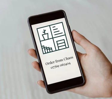 A person holding a smartphone displaying an Order from Chaos contact screen with minimalist home organization icons.