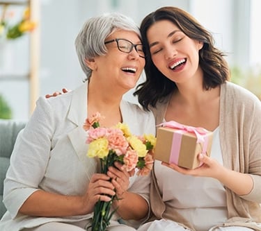 a woman holding a gift box with flowers