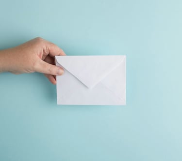 a hand holding a white envelope