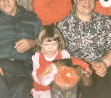 a family photo of a man and a woman with a little girl between them. the little girl is scowling.