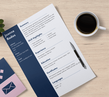 A CV resting on a table besides a cup of black coffee