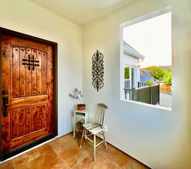 Welcoming entryway with a warm stained wood door and seating area.