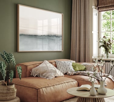 Minimalist abstract landscape with soft grey-beige gradients framed above a leather sofa