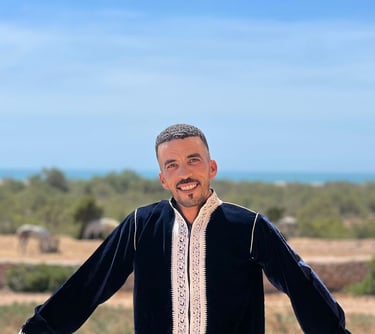 homme souriant avec des chevaux dans le fond 