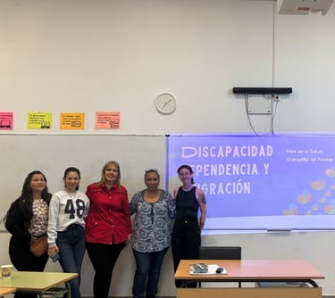 un grupo de personas posando al lado de una presentación en un taller