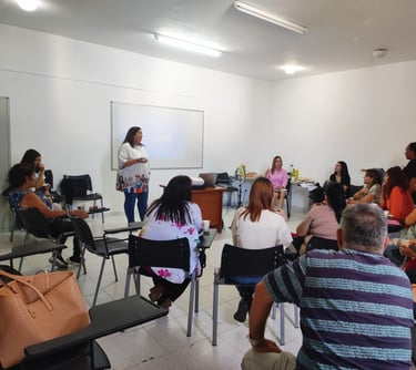 una mujer de camiseta blanca dando un taller a una clase