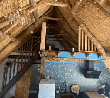 Livingroom sous les combles et le toit en chaume, mezzanine et escalier