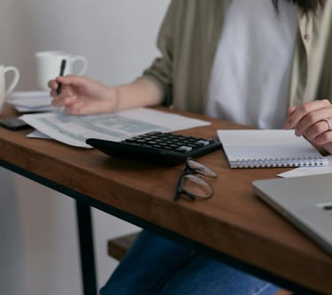 Assistante administrative : calculatrice et nombreux papiers triés et rangés, gestion des commandes