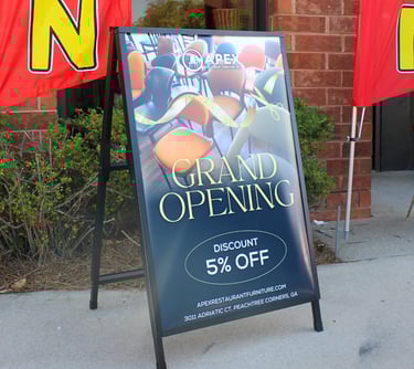 a sign board with a grand opening sign