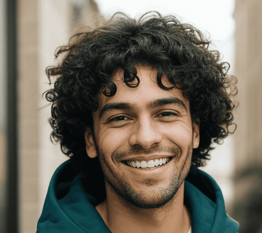 a man with curly hair and a green hoodie