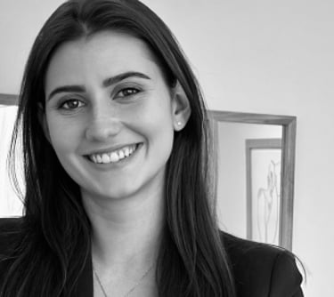 a woman in a suit and tie smiling for the camera