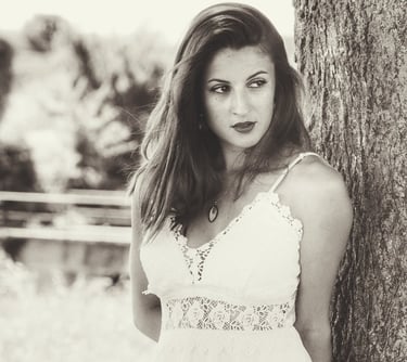 Une jeune belle femme adossée à un arbre