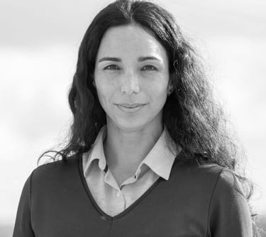 una mujer sonriendo y mirando a la cámara en foto blanco y negro