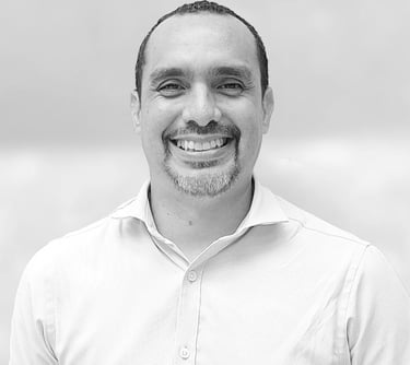 un hombre con camisa blanca sonriendo en foto blanco y negro