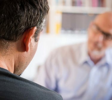 a man in a blue shirt is looking at a cell phone