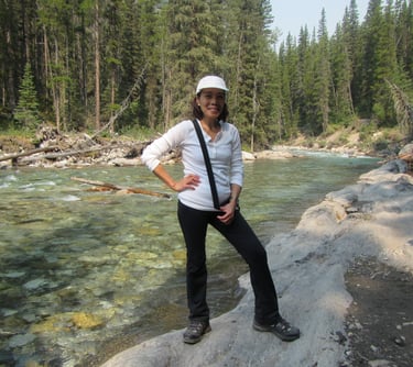 a person standing on a rock by the cascade river