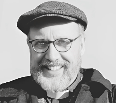 a picture of Rev. Mark Davidson wearing a flat cap and smiling at the camera