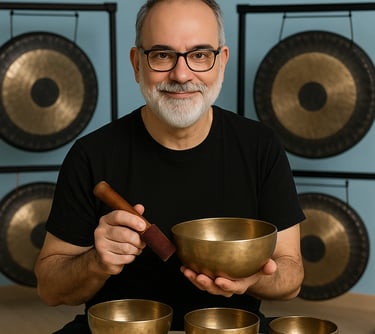 a man with a beard and glasses holding a bowl of singing bowls