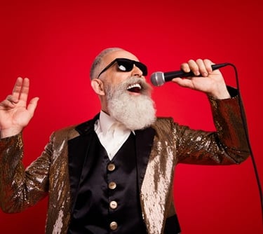 a older man with a beard and sunglasses on a red background