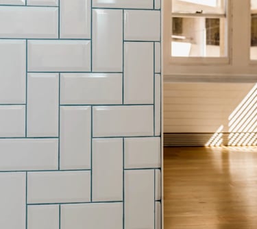 a white tiled bathroom with a white tile floor