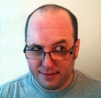 a man with glasses and a gray shirt