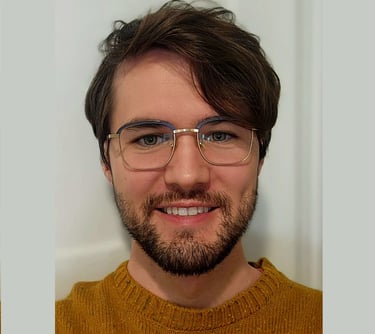 smiling man with glasses,, beard, and brown hair