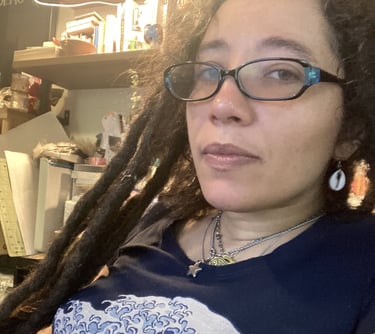 a woman with dreadlocks and glasses